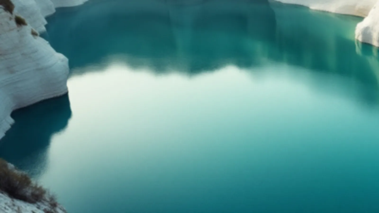 An old flooded stone quarry with still turquoise water and pale cliffs in soft morning light, the FundsQuarry view of online loans for any credit, $100 – $5,000